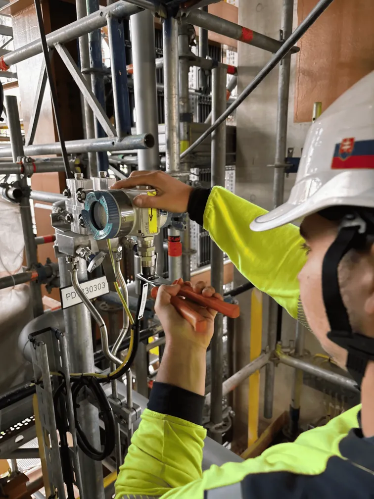 Technician adjusting industrial pressure transmitter at construction site
